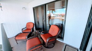 Un balcone con sedie in vimini e un tavolino.