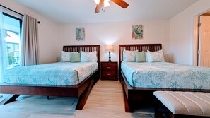 A hotel room with two beds, a nightstand, a ceiling fan, and artwork on the walls. - 2nd floor Serene Views updated Villa sleeps 8 (Panama City Beach)