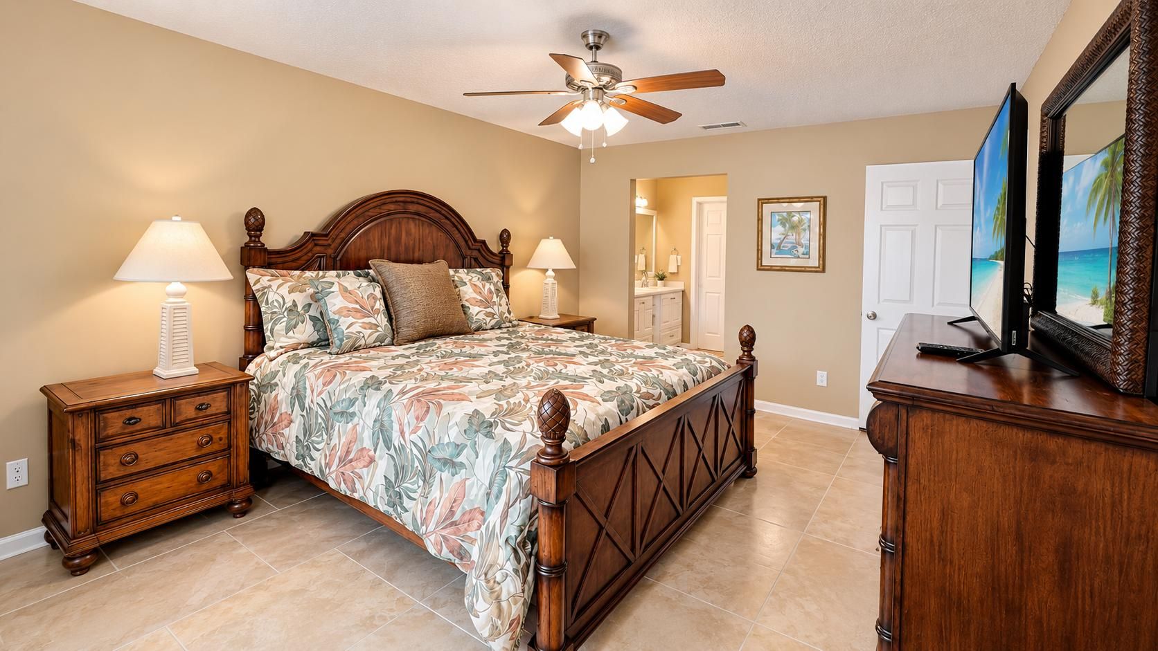 A bedroom with a bed, nightstands, a dresser, a ceiling fan, and a television.