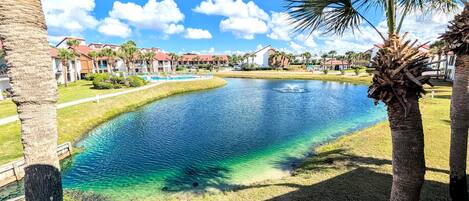 View from balcony overlooking pond with fountain and lakefront pool