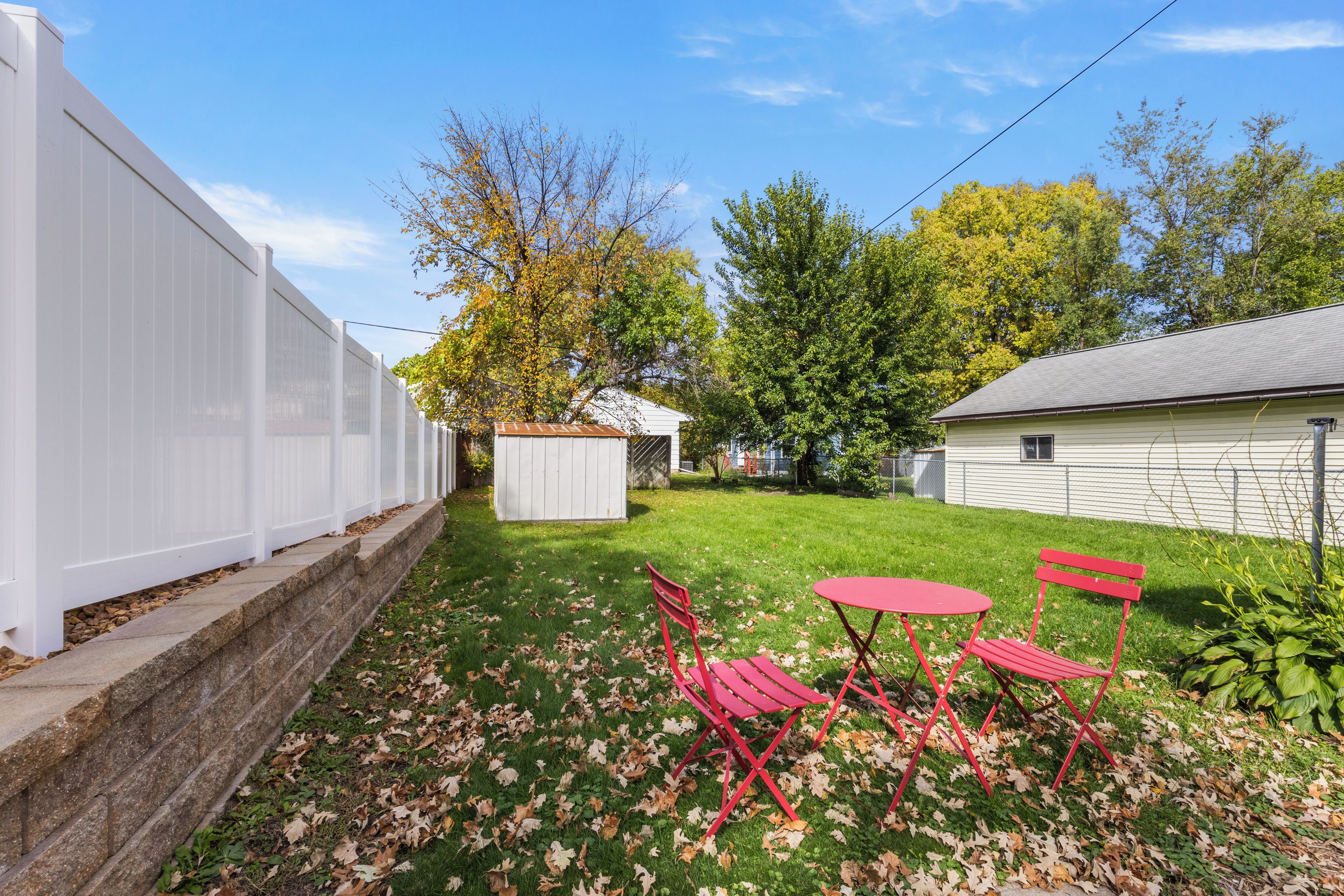 Private fenced backyard with sunny bistro seating and green open space