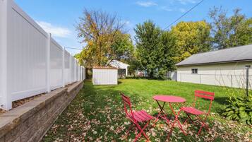 Private fenced backyard with sunny bistro seating and green open space