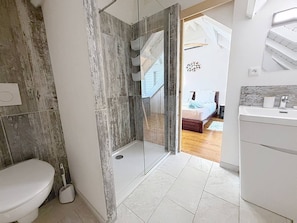 Ein Badezimmer mit Dusche, Toilette und Waschbecken.