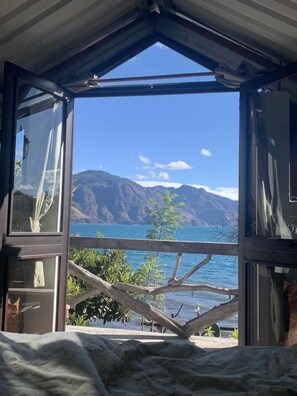 A room with a view of a mountain and a body of water. - Our Birdhouse - Relax & Swim - Your Peaceful Getaway (San Pedro La Laguna)