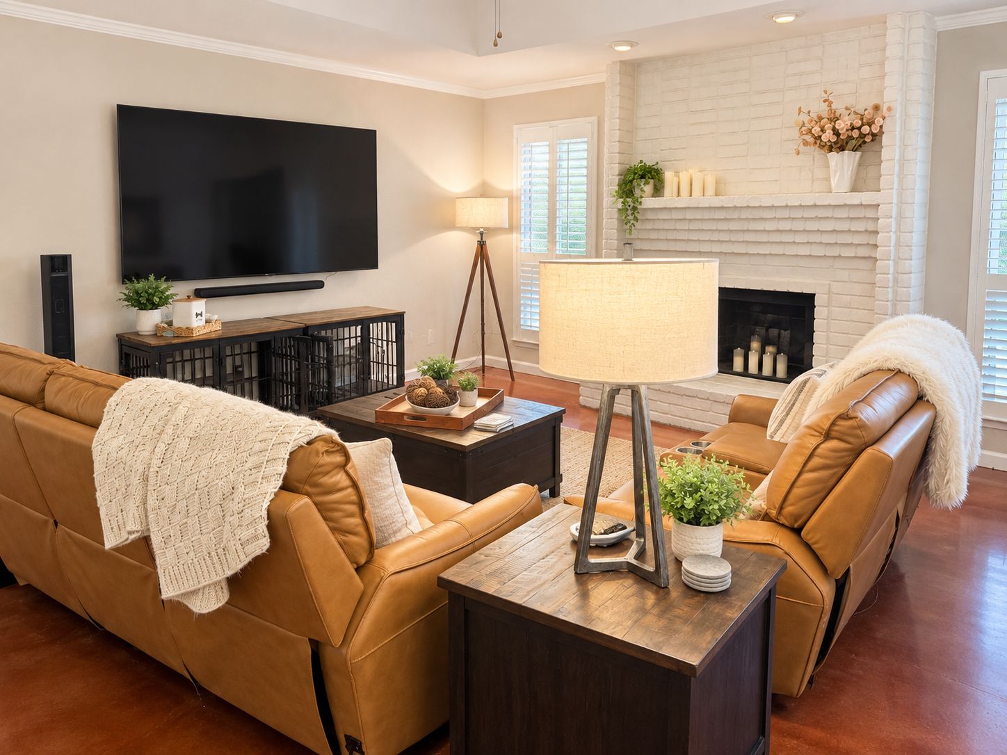 Una sala de estar con sofá, mesa de centro, lámpara, chimenea y televisor de pantalla plana.