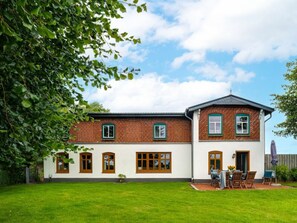 Ein zweistöckiges Haus mit Ziegelaußenwand, weißen Außenwänden und mehreren Fenstern.