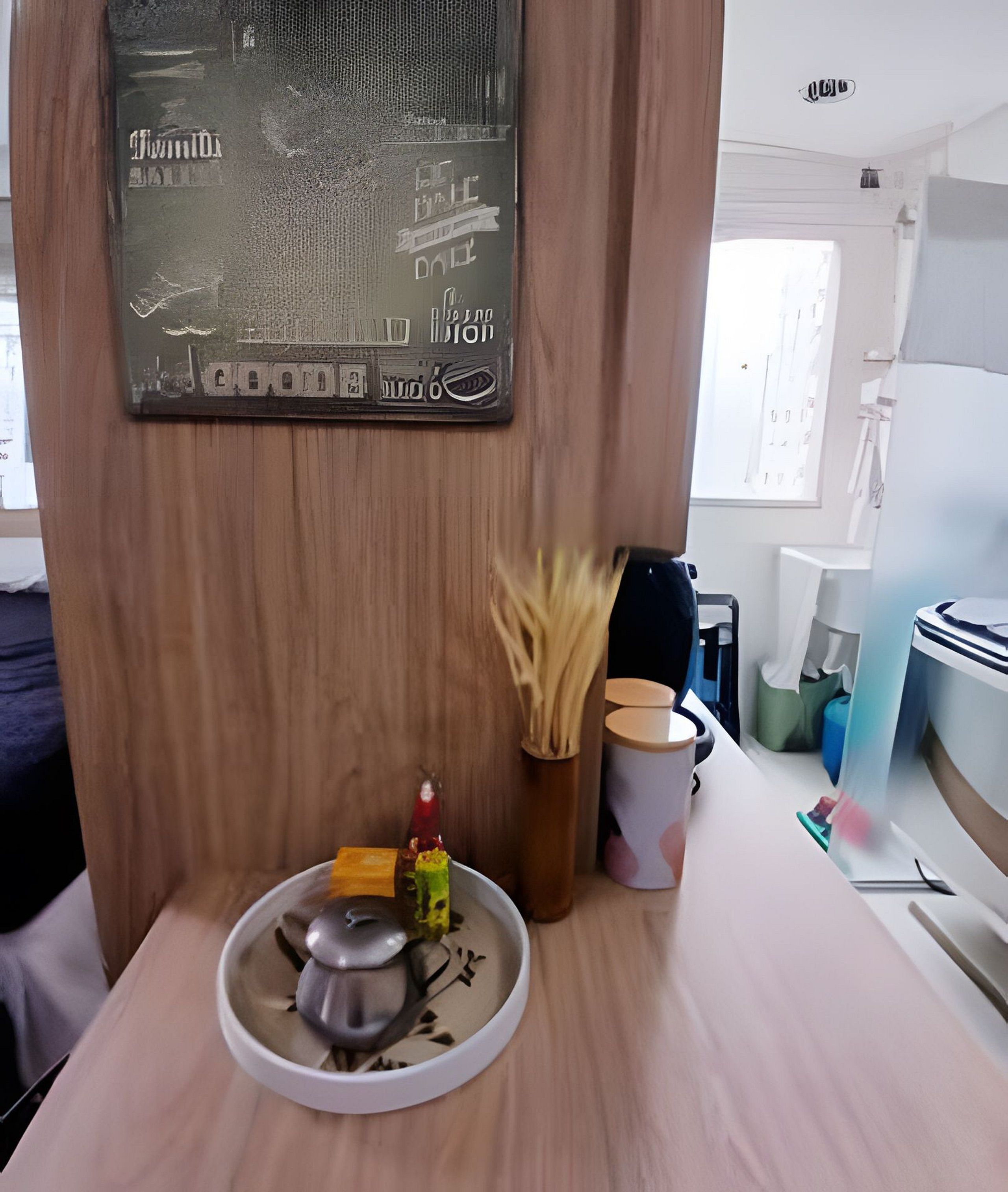 A wooden wall with a framed map and a small table with a mouse, a candle, and a cup.