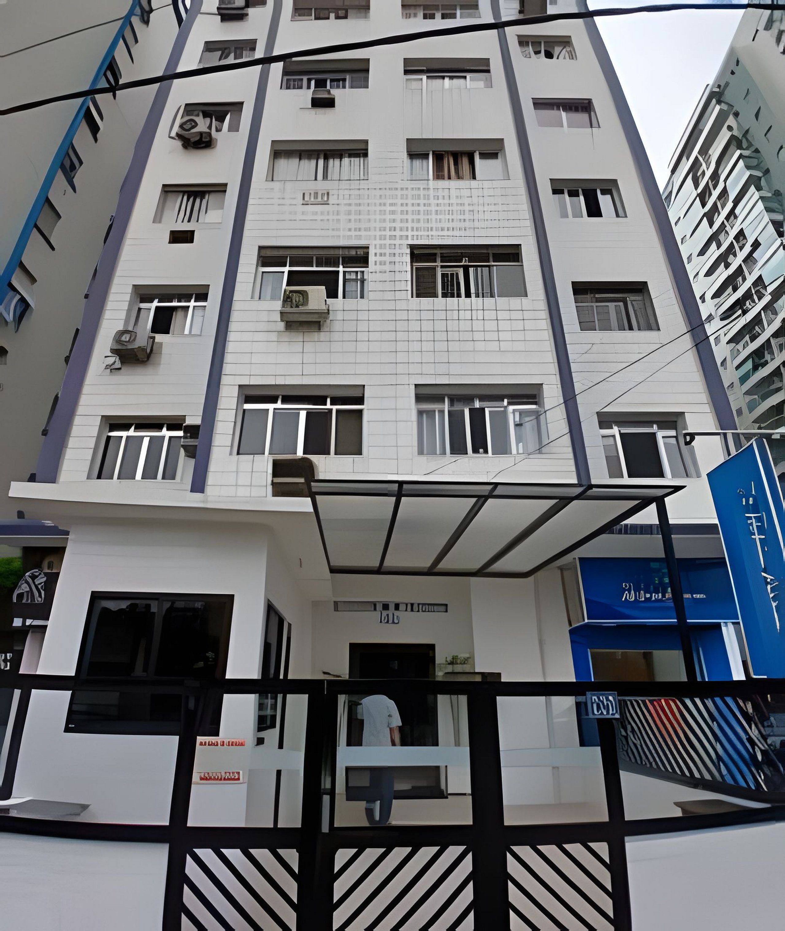 A multi-story building with a modern architectural design, featuring a central entrance with a glass canopy and a sign above it.