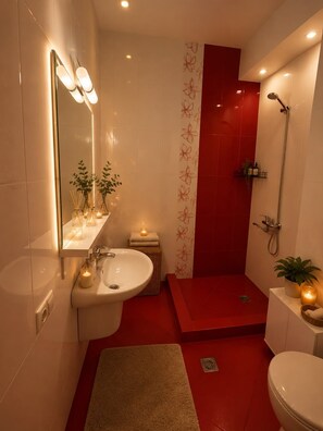 Ein modernes Badezimmer mit einem weißen Waschbecken, einem Spiegel und einer roten Duschkabine.