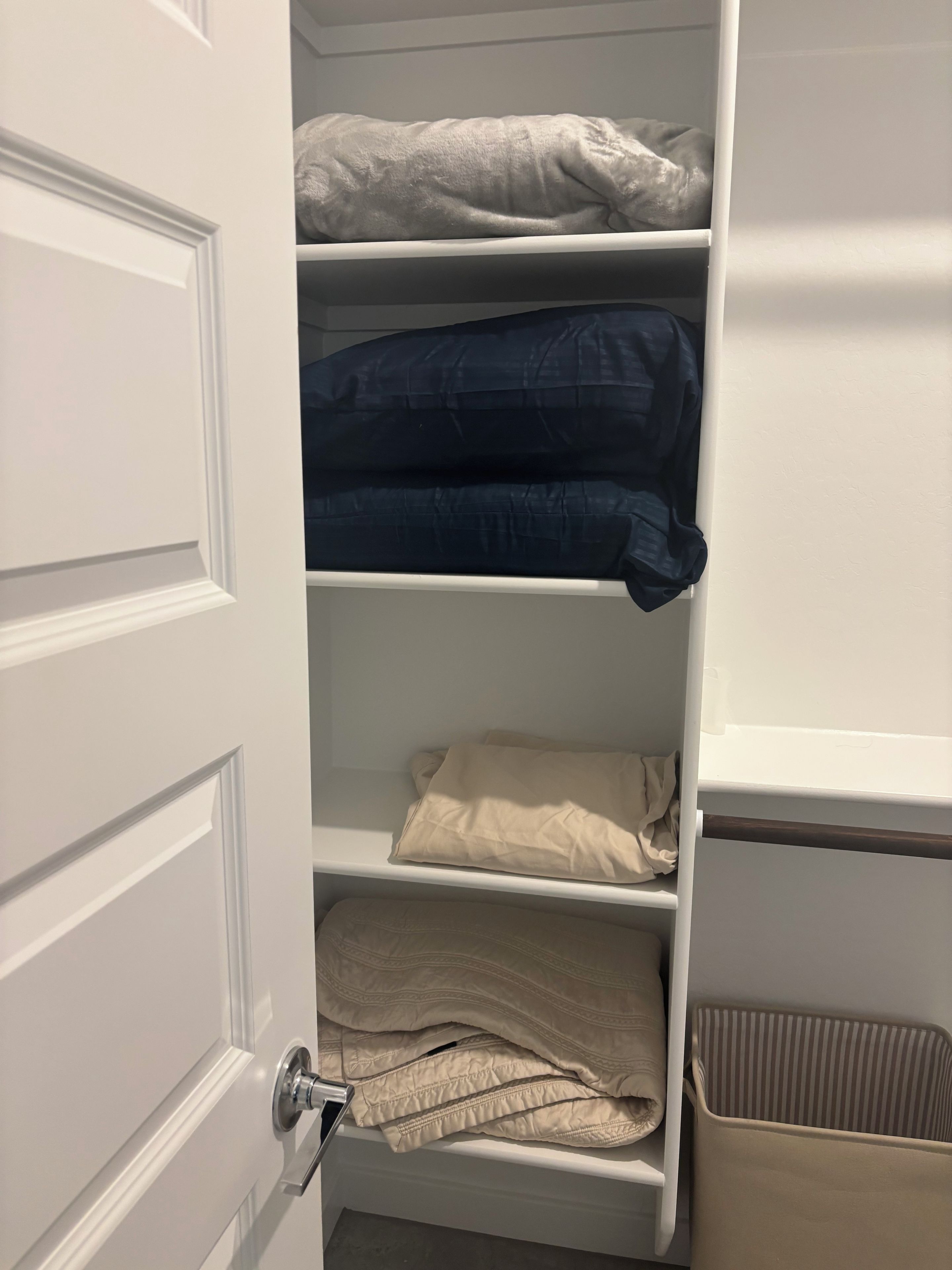 A closet with multiple shelves containing folded clothing.
