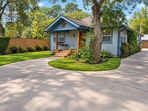 A single-story house with a front porch, a star decoration, and a well-maintained lawn. - Spacious 4-bedroom house in peaceful Houston with Fenced Yard! (Houston)