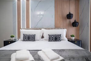 Un dormitorio moderno con una cama grande, dos mesitas de noche y paneles decorativos en la pared.
