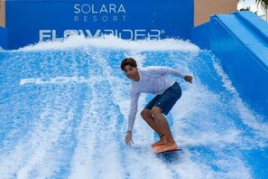 A person surfing on a wave at Solara Resort. - Luxury 9BR Home Near Disney | Solara Resort 81SA (Kissimmee)