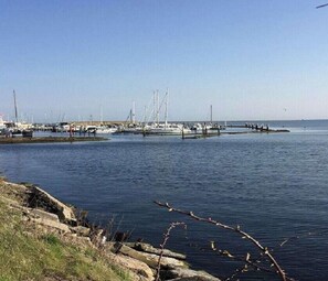 Un port de plaisance avec des bateaux amarrés et une jetée qui s’avance dans l’eau.