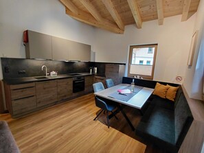 Une cuisine moderne avec des meubles en bois, une table à manger et un canapé.