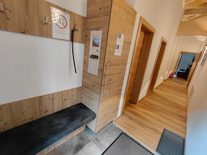 A wooden interior with a bench, a door with a sign, and a corridor leading to another room. - Modern Holiday Apartment in a Quiet Location (Laengenfeld)