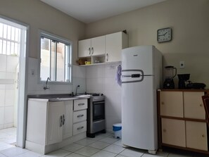 Una cocina compacta con refrigerador, estufa y pileta.