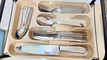 Un set di stoviglie in acciaio inossidabile in una scatola beige con manici.