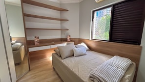 Un dormitorio moderno con cama, cabecero de madera, estante empotrado y ventana con vistas.