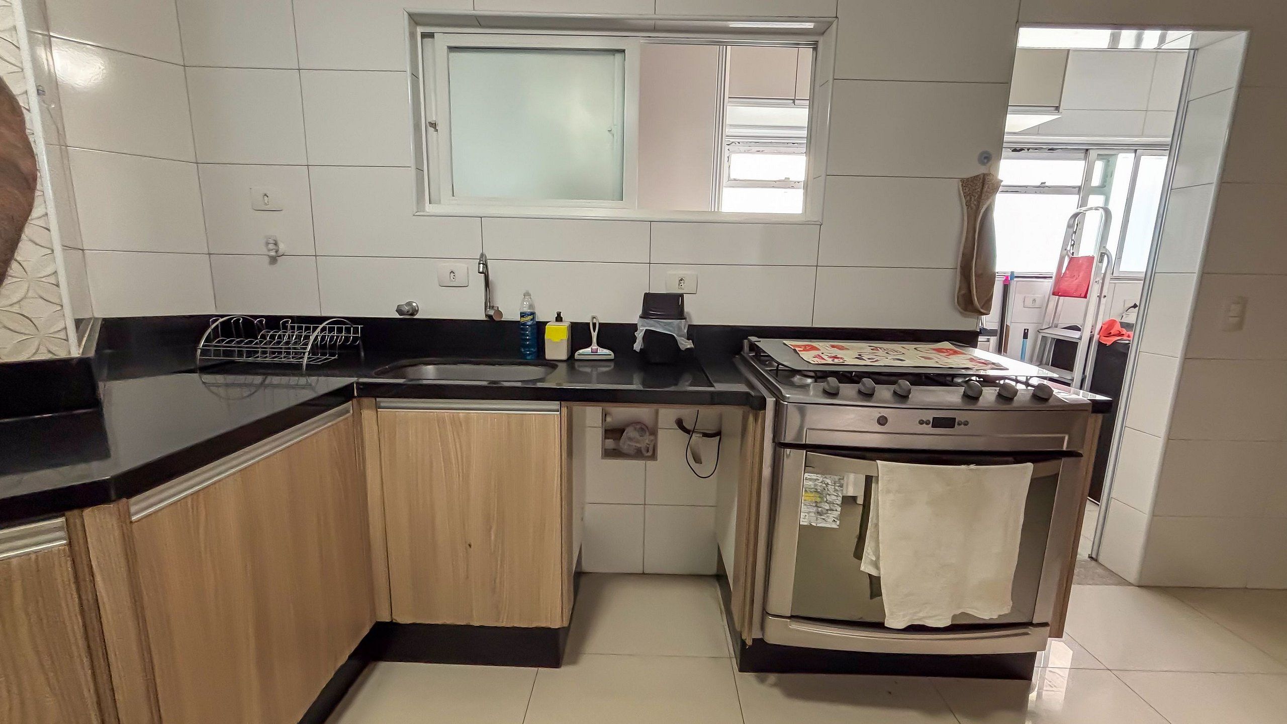 A kitchen with a stove, sink, and a window above the sink.