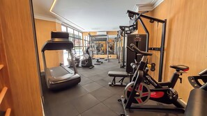Un gimnasio con cinta de correr, bicicleta estática y máquinas de pesas.