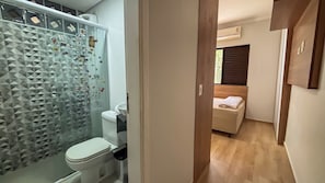Un baño con una cabina de ducha moderna de líneas geométricas, un inodoro y un lavabo.