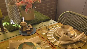 A dining table set with plates, cutlery, a teapot, and a vase with flowers. - STANZE CENTRO STORICO CAGLIARI (Cagliari)