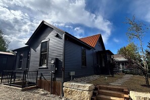 A two-story house with a sloped roof, a front porch, and a fenced yard. - Walk to Slopes & Main St from Historic Modern House (Breckenridge)