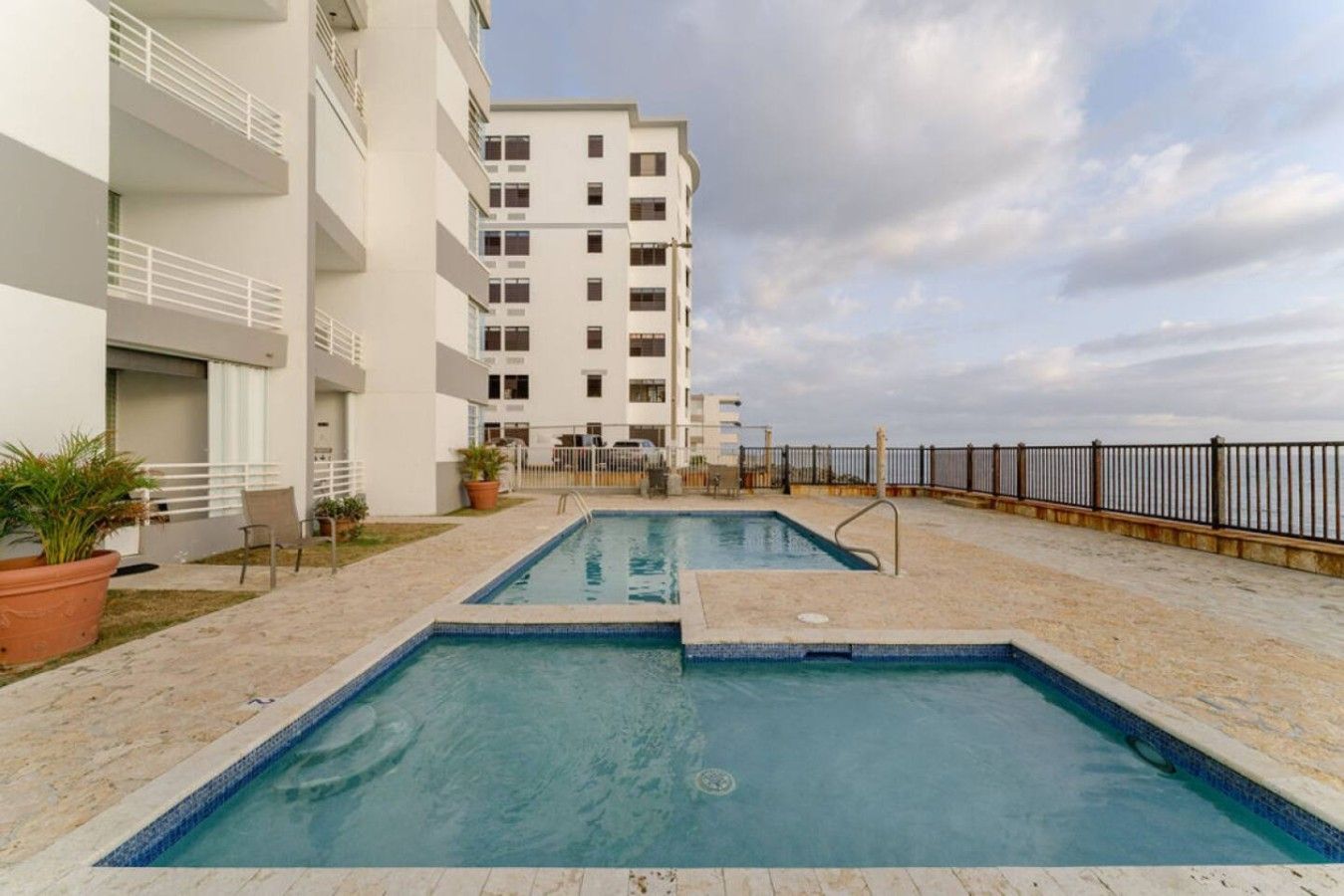 A swimming pool area with a building in the background.