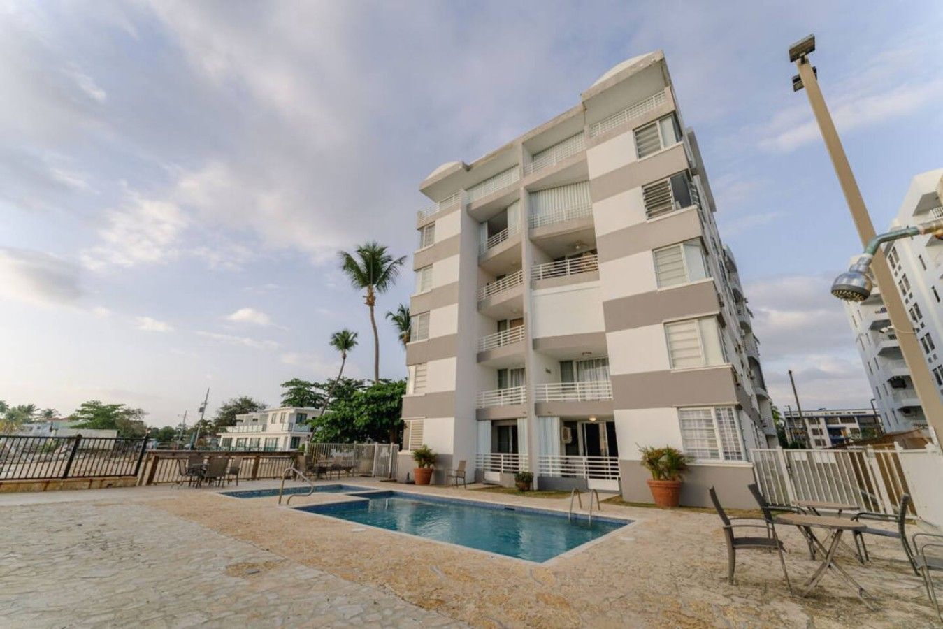 A multi-story residential building with a swimming pool and outdoor seating.