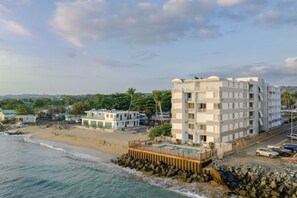 A beachfront hotel with a pool, multiple balconies, and a view of the ocean. - Costa Córcega 5A | Beachfront, Pool & Beach Access (Rincón)