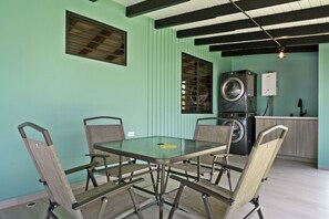 A dining area with a table and chairs, a washing machine, and a kitchen area. - La Casita de Pepe y Yiya | Private Pool & Terrace (Luyando)