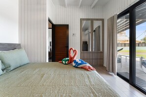 A bedroom with a bed, a door leading to another room, and a view through a glass door. - La Casita de Pepe y Yiya | Private Pool & Terrace (Luyando)