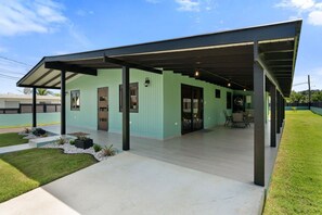 Un bâtiment moderne doté d’un patio couvert, d’une façade verdoyante et surplombant un ciel dégagé.