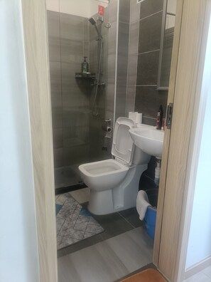 A bathroom with a shower, toilet, and sink. - Modern Makumbi Park Studio Near JKIA & SGR (Nairobi)