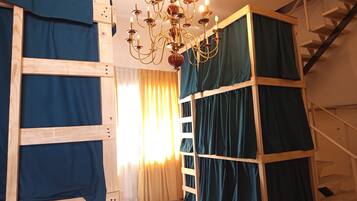 Una habitación con una escalera de madera, una araña y una escalera.