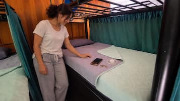 A bunk bed with a smartphone and coins on the mattress.