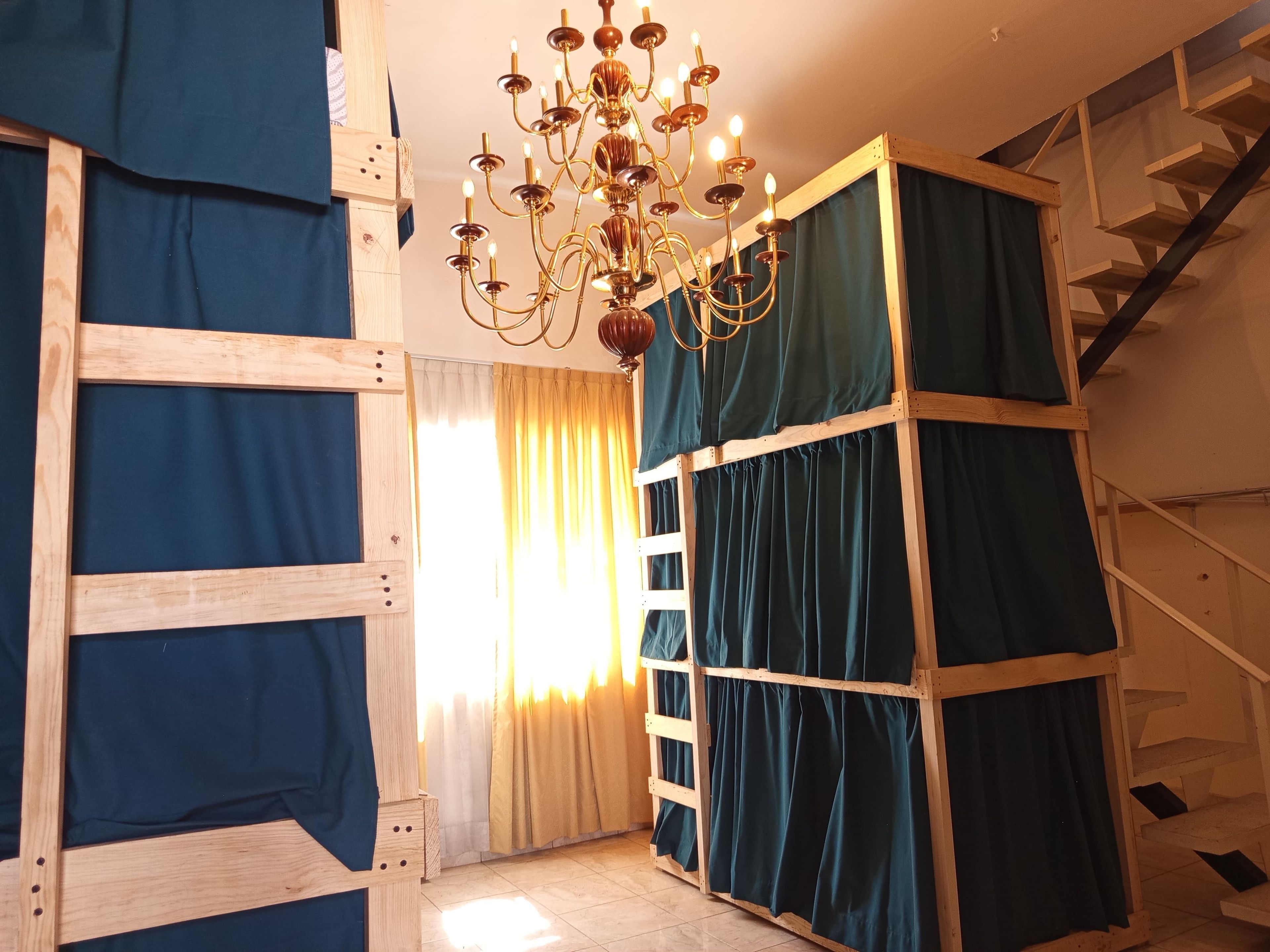 A room with a wooden ladder, a chandelier, and a staircase.