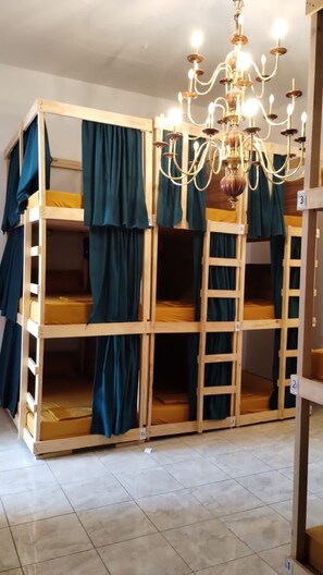A bunk bed room with a chandelier, curtains, and numbered storage units. - HOSTEL & LOFTS CASA LUMA (Guadalajara)