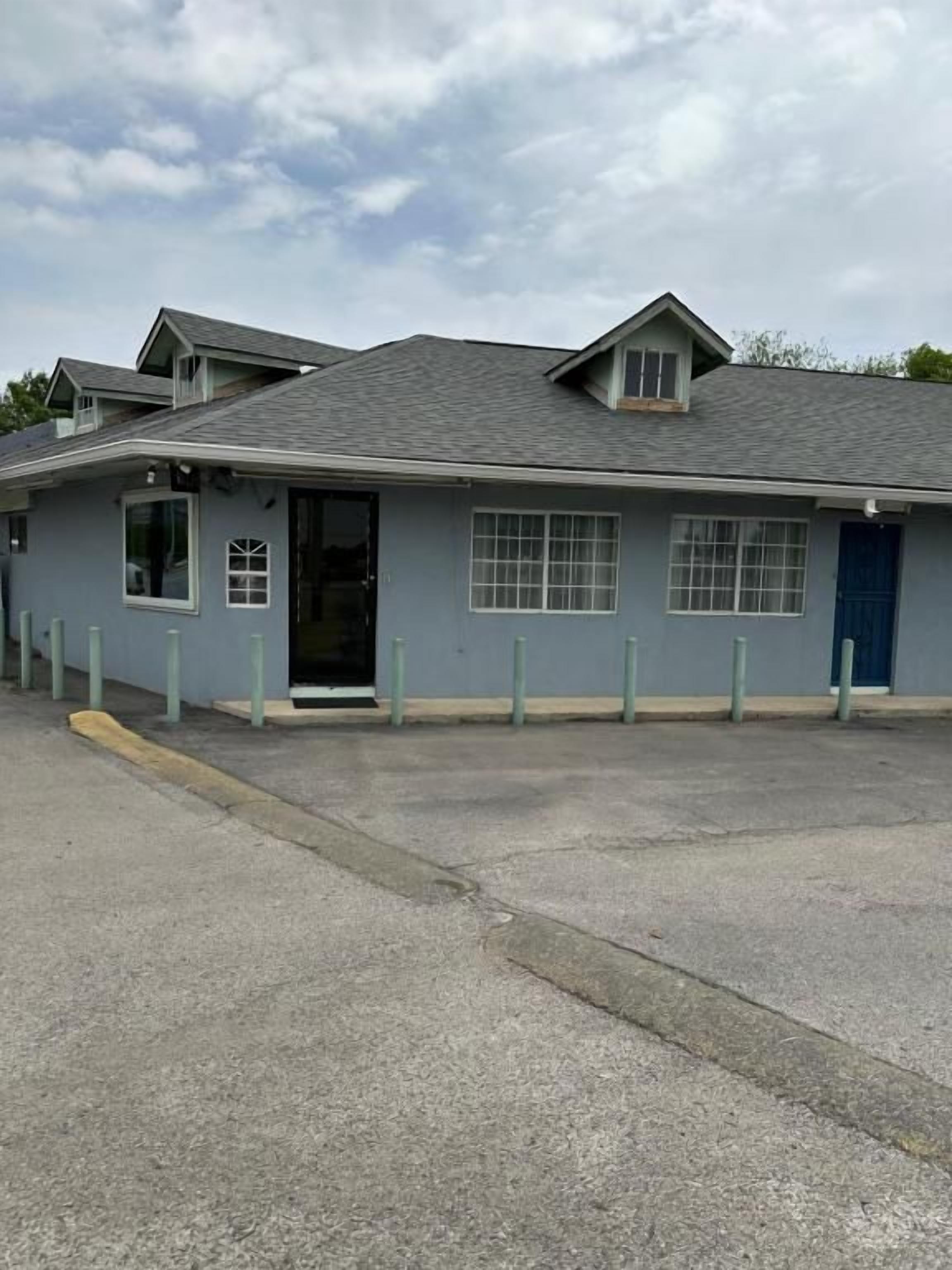 A building with a flat roof, a door, and windows.