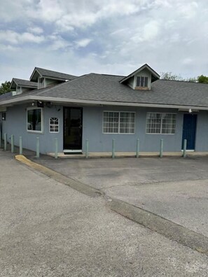 A building with a flat roof, a door, and windows. - Sands Motel (San Antonio)
