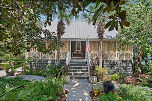 A house with a porch, steps leading to the entrance, and a flag. - New Santa Rosa Beach Retreat| 3BR/2.5BA (Santa Rosa Beach)