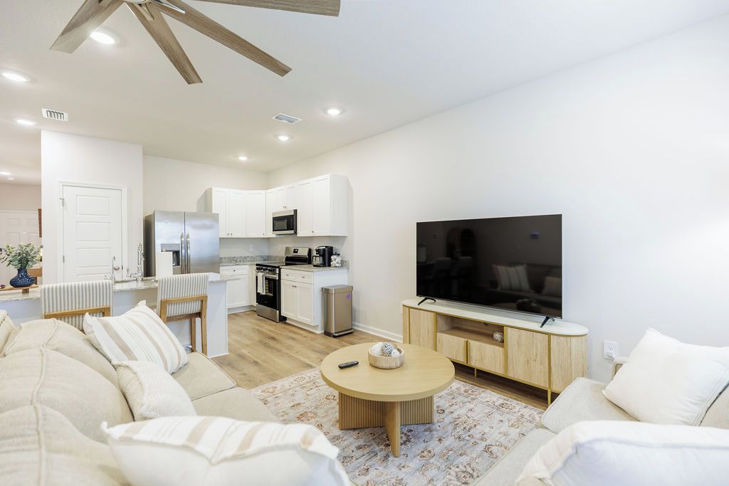 Ein modernes Wohnzimmer mit einer Couch, einem Couchtisch und einem Flachbildfernseher.