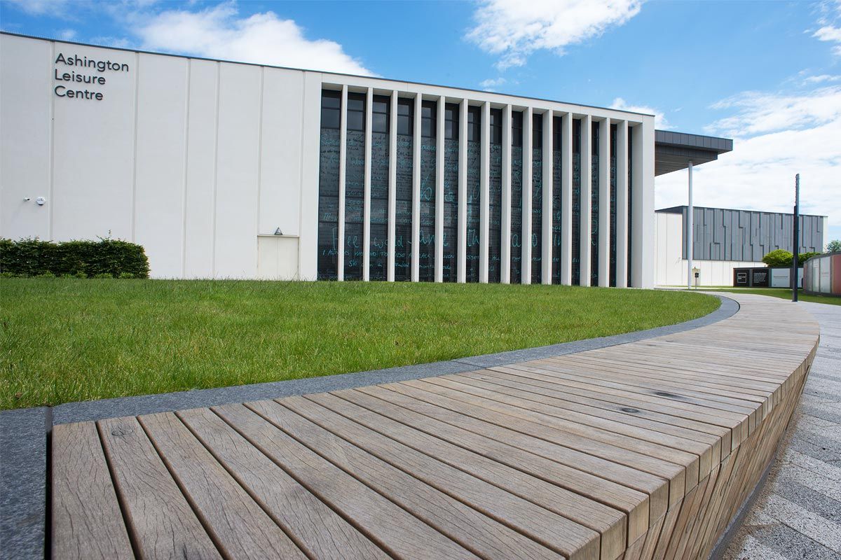 Een modern gebouw met een bord waarop staat 'Ashington Leisure Centre'.