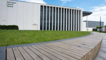Een modern gebouw met een bord waarop staat 'Ashington Leisure Centre'.