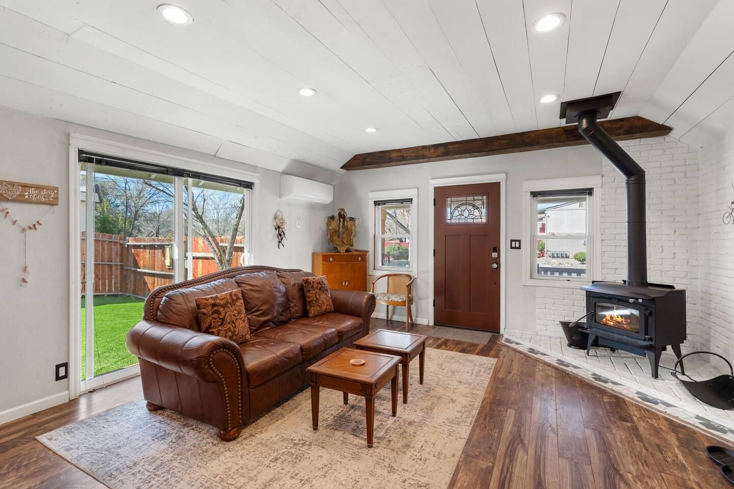 A living room with a leather sofa, wooden coffee table, and a fireplace.