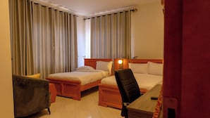 A hotel room with two beds, a desk, a chair, and a wardrobe. - Amani Residence Entebbe (Entebbe)