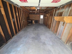 A room with a concrete floor, wooden walls, and a door at the far end. - West Campus Peaceful Paradise (Fort Collins)