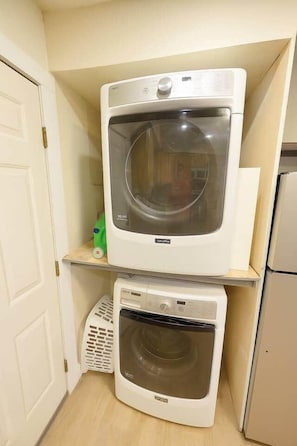 A laundry room with a top-loading washing machine and a front-loading dryer. - West Campus Peaceful Paradise (Fort Collins)