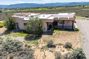 Una casa moderna con techo plano, rodeada por un paisaje desértico.